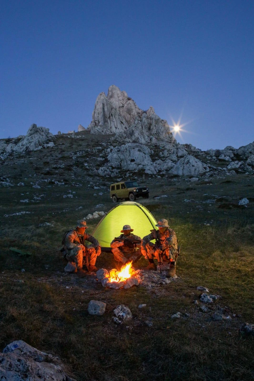 Field training camp in remote terrain at dusk